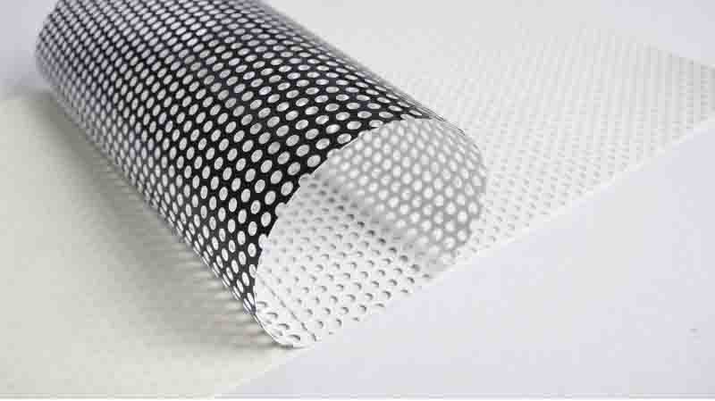 Perforated Vinyl rolled out on table ready to be printed on